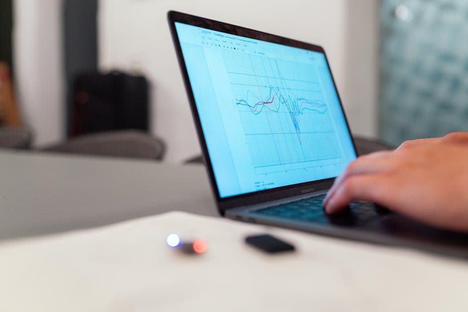 A person working on graph analysis on a laptop for data monitoring and research