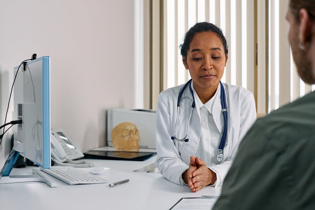 A healthcare provider and patient reviewing a printed symptom log together during a clinic visit