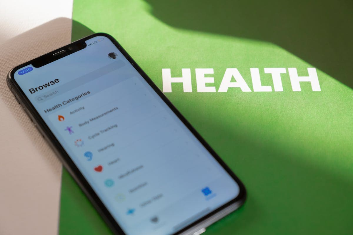 A close-up of a smartphone health app showing a weekly symptom tracker with severity ratings and notes