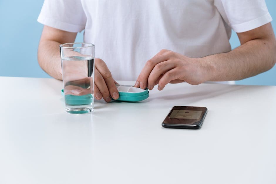 Organized daily wellness station with supplements, a glass of water, and a phone showing a medication tracking app