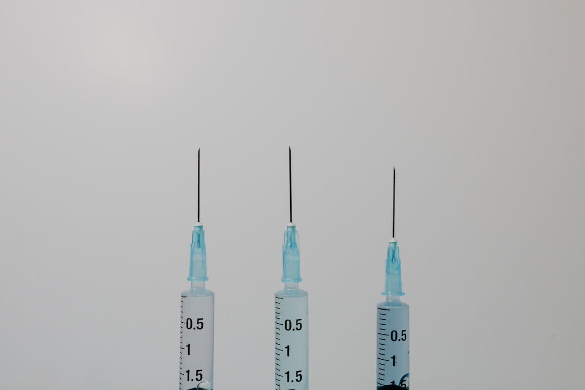 Close-up comparison of an insulin syringe next to a standard intramuscular syringe on a medical tray
